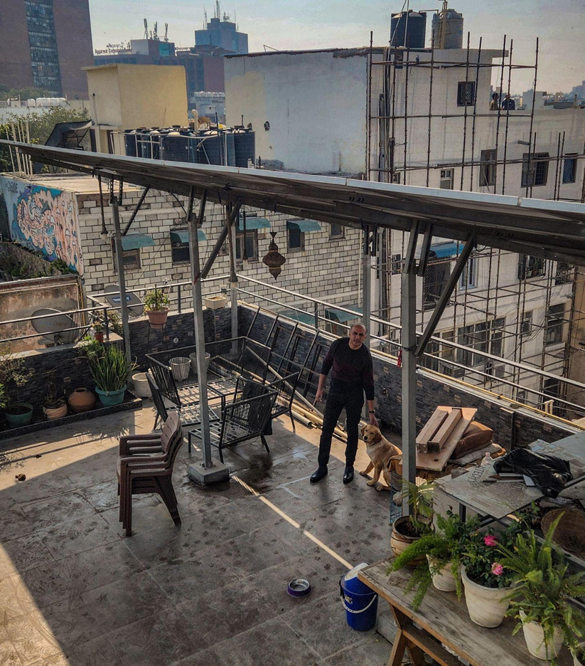 Amit Bajaj standing beneath his 6 kW solar rooftop system. Photo by Pallav Jain