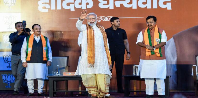 Narendra Modi waves to supporters as he arrives at party headquarters in New Delhi