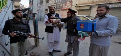 Policeman guarding polio worker Policeman guarding polio worker