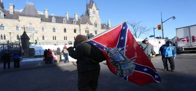 A supporter carries a Confederate flag during the "Freedom Convoy" protests against COVID-19 vaccine mandates and restrictions in front of Canadian parliament in Ottawa(Photo: JTA)