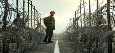 Screen shot of actor Diljit Dosanjh who portrays Nirvair Singh in the film Main Vaapas Aaunga, standing between two countries. Screenshot via film.